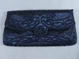 une pochette bleue ornée de perles sur fond blanc
