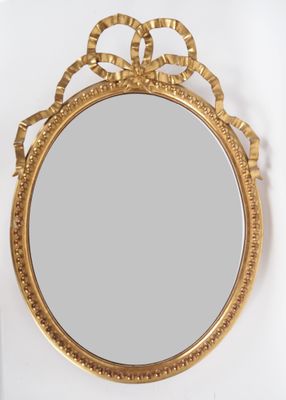 une image d'un miroir encadré d'or sur un mur blanc