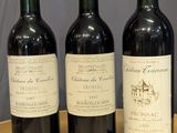 three bottles of wine are lined up on a wooden table
