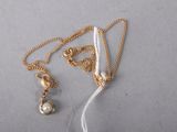 necklace with a pearl and a gold chain on a white background
