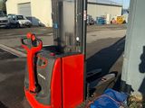 a red and black forklift sitting on the side of the road