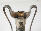 a silver vase that is sitting on a table
