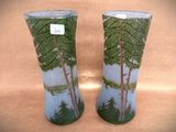 two vases with trees painted on them sitting on a table