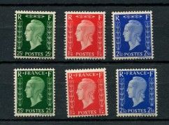 a group of four different colored postages on a black surface