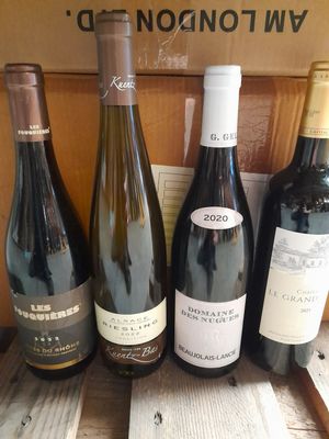plusieurs bouteilles de vin sont alignées sur une table en bois