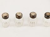 three glass salt and pepper shakers on a white surface