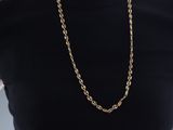 the woman is wearing a black shirt and a gold chain necklace
