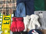 une boîte remplie de vêtements et de gants posée par terre