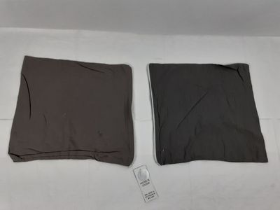 Deux vêtements sont posés sur un lit, à côté d'une télécommande