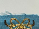 a blue ribbon with a gold bow on it