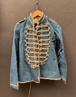 une vieille veste bleue suspendue à un cintre accroché au mur