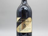 une bouteille de vin rouge posée sur une table blanche