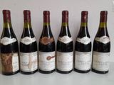 six bottles of wine are lined up in a row on a table