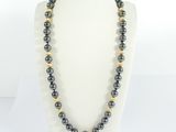 a black and gold beaded necklace on a mannequin
