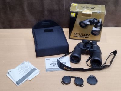 une boîte de jumelles posée sur une table à côté d'une paire de lunettes