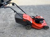 une tondeuse à gazon rouge posée sur le sol