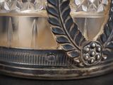 a close up of a silver plate with a feather on it