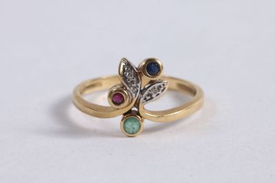un gros plan d'une bague en or sertie de deux pierres de couleurs différentes