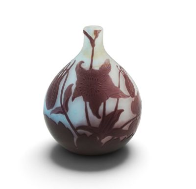 un vase orné d'un motif floral sur une surface blanche