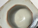 a white vase with a brown rim sitting on top of a table