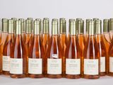 des bouteilles de vin rosé alignées en rang sur une surface blanche