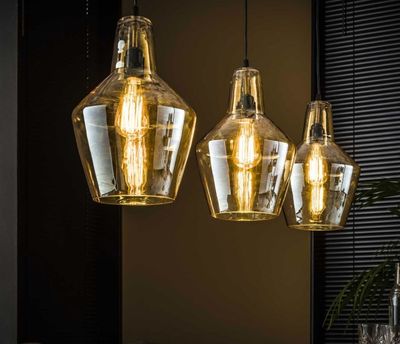 three lights that are hanging over a table
