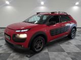la voiture rouge est garée sur un sol en damier dans le garage