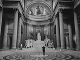 photographie en noir et blanc d'une personne debout dans un grand bâtiment