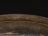 a close up of a silver plate with a black background