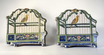 two small bird cages with birds in them on display