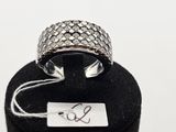 une photo d'une bague en argent sertie d'un diamant, posée sur un présentoir à bagues noir