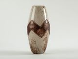 brown and white vase with geometric design on it on a white surface