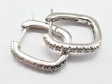 une paire de boucles d'oreilles créoles en argent sur fond blanc