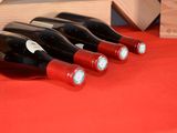 several bottles of wine are lined up on a red table