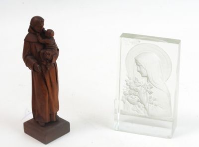 une statue représentant une femme tenant un enfant dans ses bras, à côté d'un bloc de verre