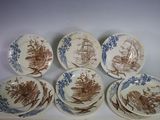 six assiettes marron et blanches, ornées de motifs marron, posées sur une table