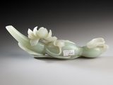 a jade sculpture of a bird with flowers on its back