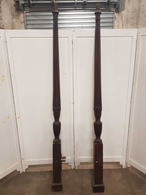 une paire de piliers anciens en bois placés dans un coin de la pièce