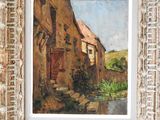 an oil painting of an old house in a frame on a brick wall