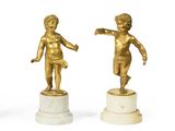 deux statues en or représentant un garçon et une fille, posées sur des socles en marbre