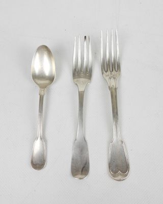 trois fourchettes et deux cuillères sur une table blanche