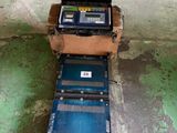 une boîte de piles posée par terre à côté d'une boîte remplie de boîtes