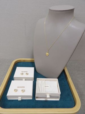 necklace, earrings, and jewelry in a display case on a table