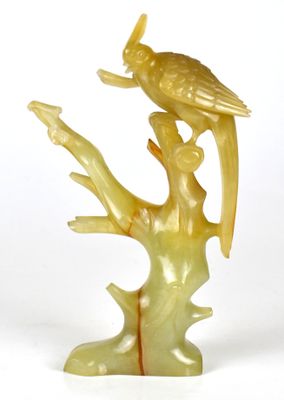 une statue représentant un oiseau perché sur une branche d'arbre