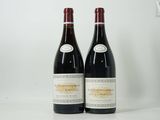 deux bouteilles de vin rouge posées sur une table blanche