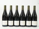 six bouteilles de vin sont alignées sur une surface blanche