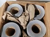 quatre rouleaux de ruban adhésif dans une boîte en carton