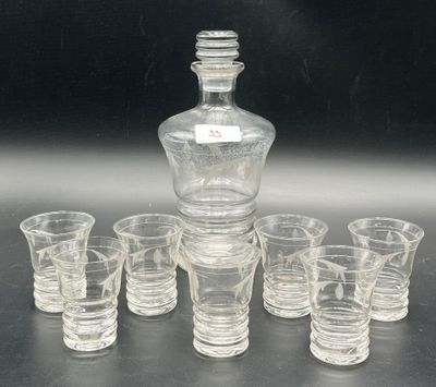 six verres à shot et une carafe posés sur une table