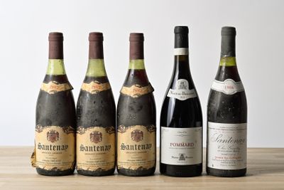 six bottles of wine are lined up on a wooden table