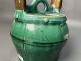 a green pot with two handles on a table